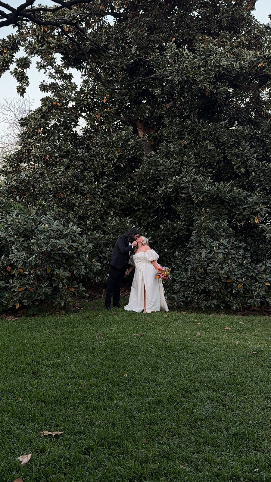 bride and groom kiss in front of an oak tree at woodbine mansion 